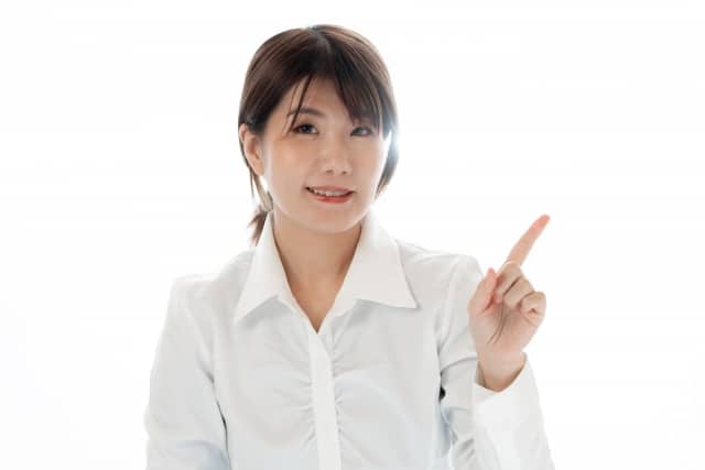 人差し指を宙に向けている女性